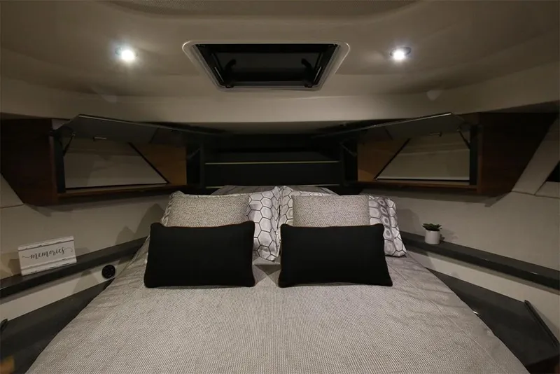 Slide: The Image of 2023 Boston Whaler 405 Conquest cabin interior with bed and storage compartments. - 14