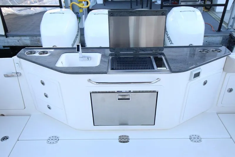 Slide: The Image of Outdoor kitchen on 2023 Boston Whaler 405 Conquest boat with sink, grill, and storage. - 18