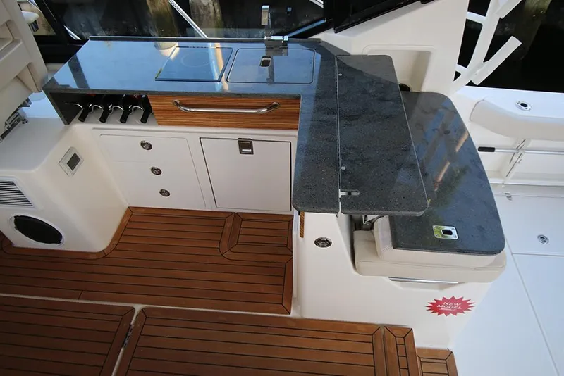 Slide: The Image of 2023 Boston Whaler 405 Conquest boat galley with wooden flooring and modern appliances. - 24