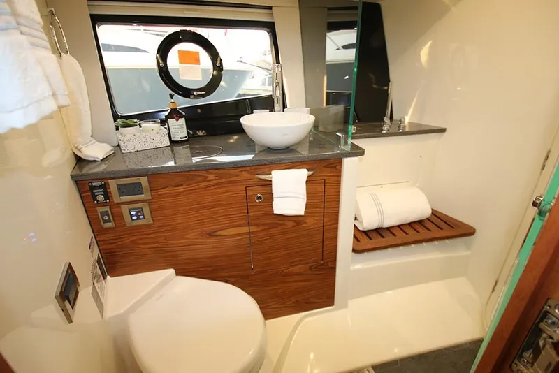 Slide: The Image of Modern bathroom in 2023 Boston Whaler 405 Conquest boat with sink, toilet, and wooden accents. - 25