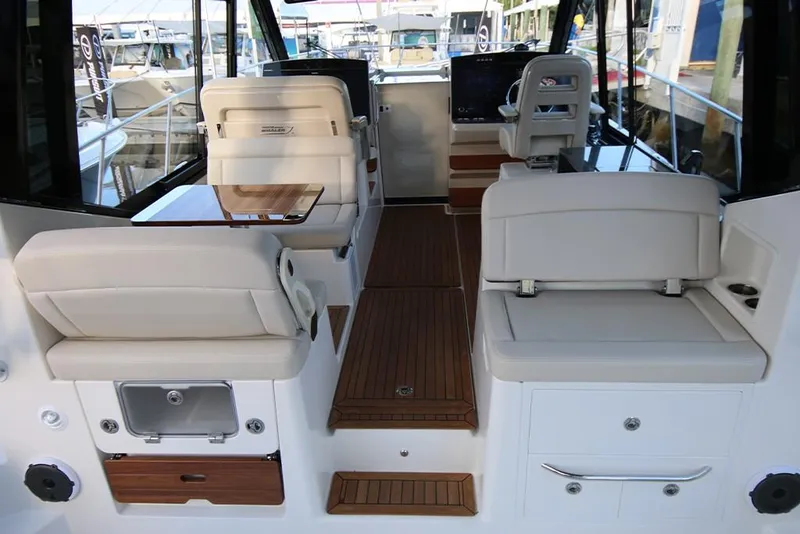 Slide: The Image of 2023 Boston Whaler 405 Conquest interior with white seating and wooden flooring. - 28