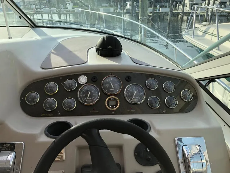 Slide: The Image of 2001 Cruisers Yachts 3470 Express dashboard with gauges and steering wheel at marina. - 11