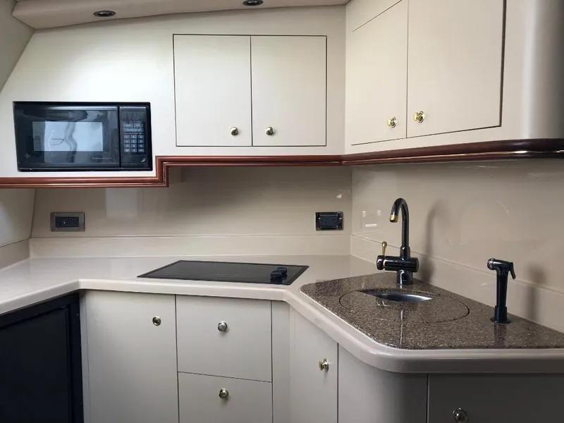 Slide: The Image of 2001 Cruisers Yachts 3470 Express kitchen with microwave, sink, and stovetop. - 15