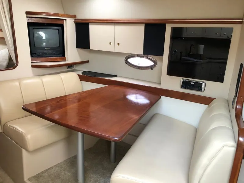 Slide: The Image of Interior of 2001 Cruisers Yachts 3470 Express with dining area and TV. - 22
