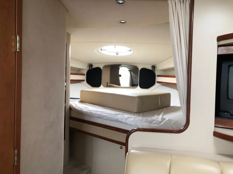 Slide: The Image of 2001 Cruisers Yachts 3470 Express cabin interior with bed and porthole. - 23