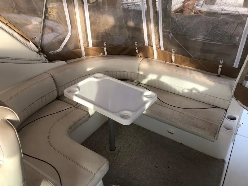 Slide: The Image of 2001 Cruisers Yachts 3470 Express interior with beige seating and table. - 8