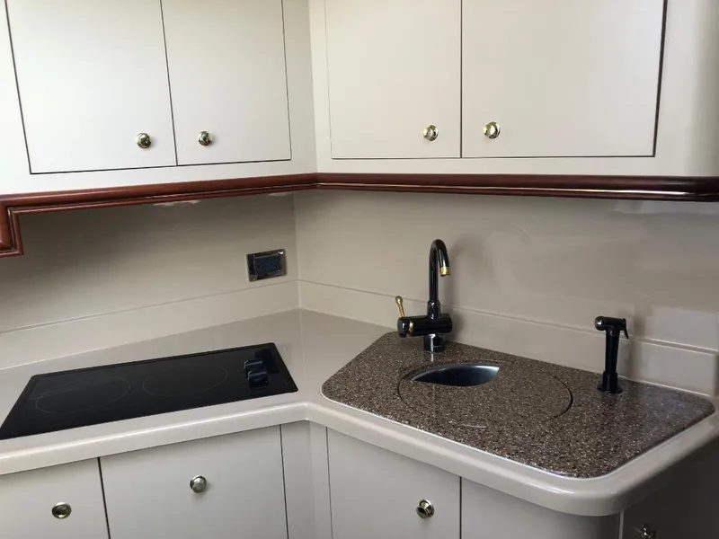 Slide: The Image of 2001 Cruisers Yachts 3470 Express kitchen with sink, stovetop, and cabinets. - 16