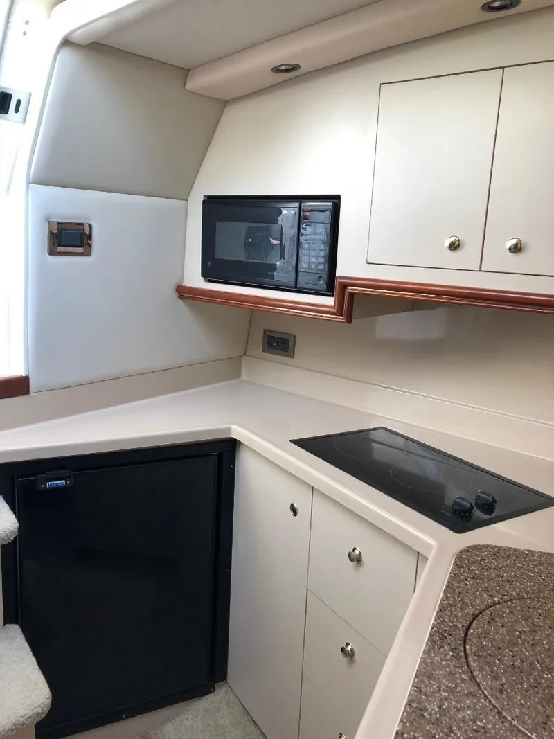 Slide: The Image of 2001 Cruisers Yachts 3470 Express kitchen with microwave, stove, and fridge. - 17