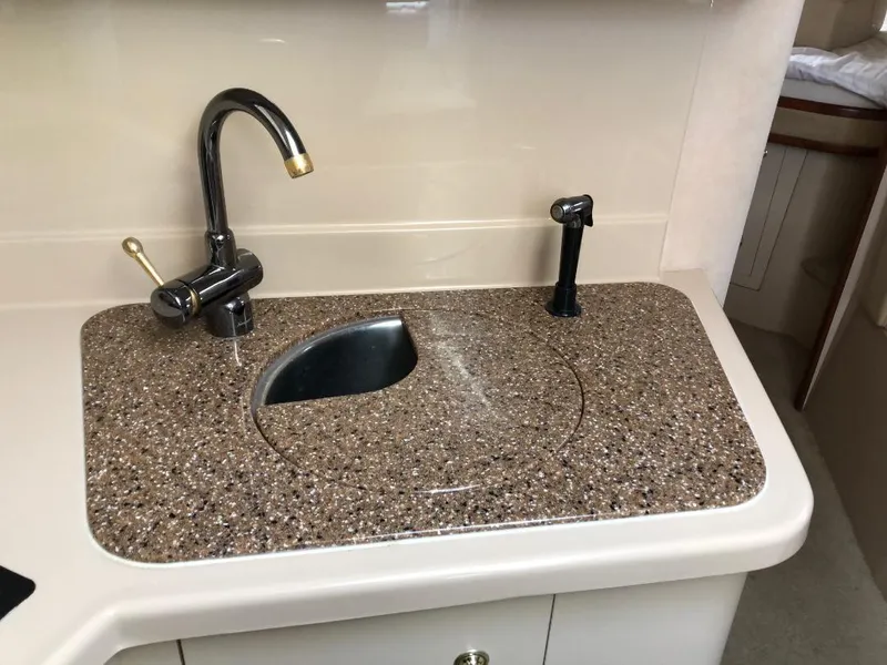 Slide: The Image of 2001 Cruisers Yachts 3470 Express kitchen sink with granite countertop and modern faucet. - 18