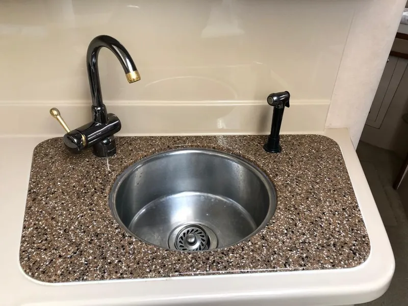 Slide: The Image of 2001 Cruisers Yachts 3470 Express kitchen sink with granite countertop and modern faucet. - 19