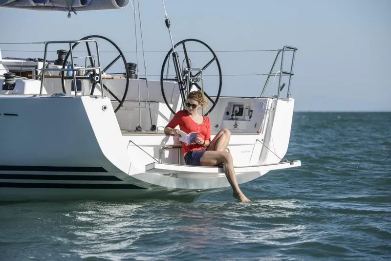 Slide: The Image of Woman relaxing on 2025 X-Yachts X4.3 sailboat, reading by the sea. - 3