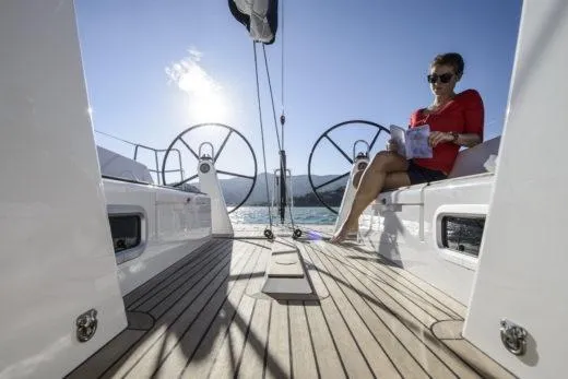 Slide: The Image of 2025 X-Yachts X4.3 yacht deck with person relaxing, reading a book. - 4