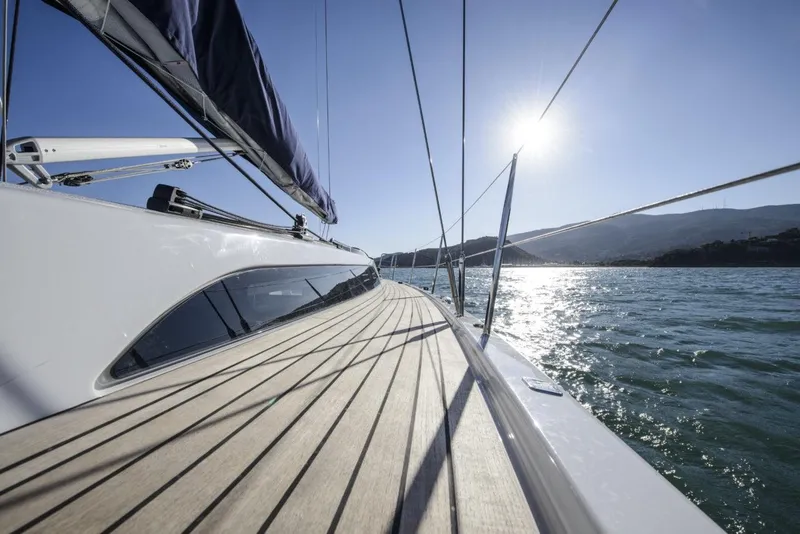 Slide: The Image of 2025 X-Yachts X4.3 sailboat on water, sunlit deck, scenic view. - 5