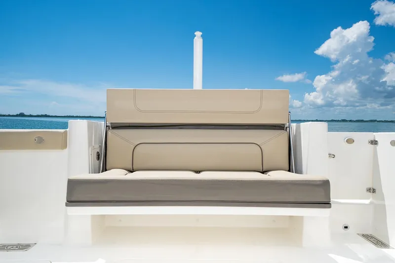 Slide: The Image of 2025 Pursuit DC 326 boat with cushioned seating, ocean view, and clear blue sky. - 17