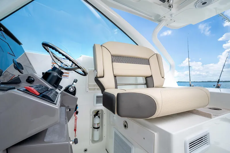 Slide: The Image of Captain's seat and helm of 2025 Pursuit DC 326 boat with ocean view. - 18