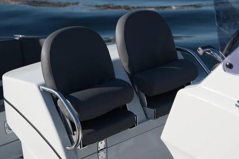 Slide: The Image of 2024 Grand Inflatables G850 boat seats with armrests on a calm water background. - 10