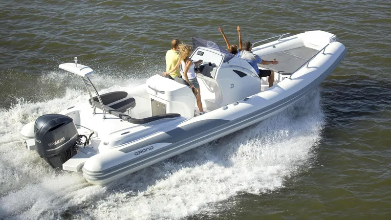 Slide: The Image of 2024 Grand Inflatables G850 boat cruising with passengers on a sunny day. - 4