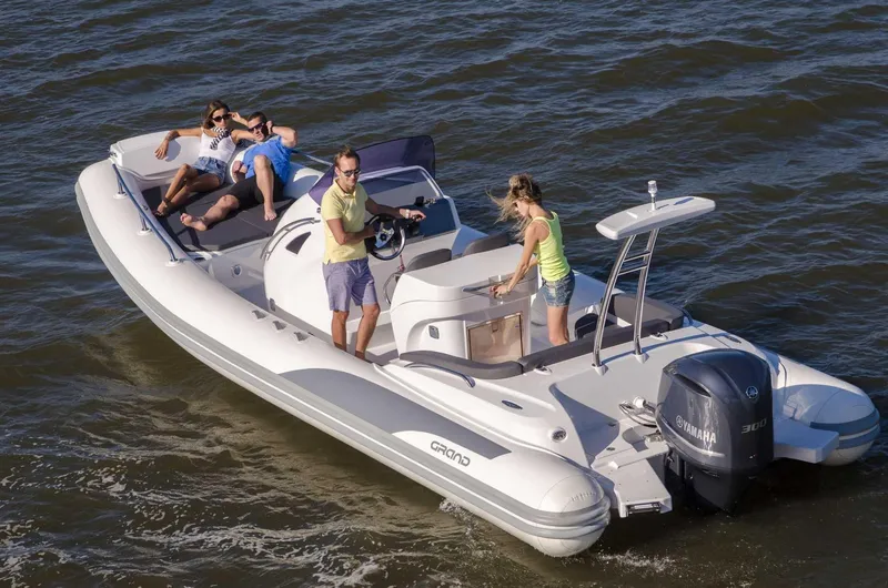 Slide: The Image of 2024 Grand Inflatables G850 boat with people enjoying a ride on the water. - 5