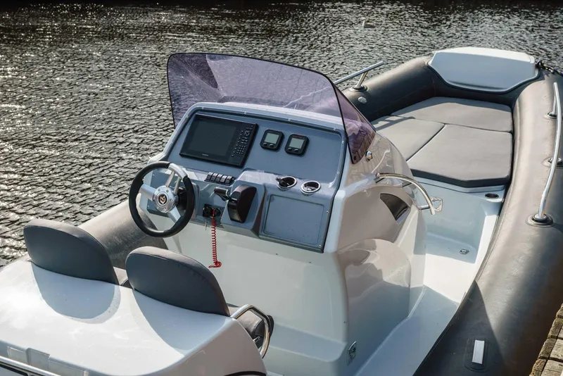 Slide: The Image of 2024 Grand Inflatables G850 boat with modern dashboard and seating on water. - 6