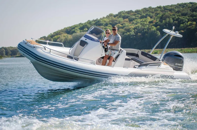Slide: The Image of 2024 Grand Inflatables G650 boat cruising on a lake. - 25