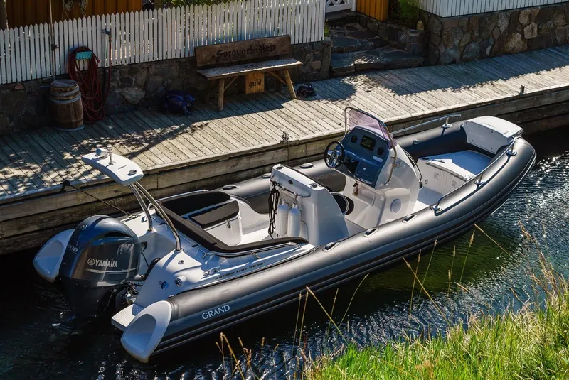 Slide: The Image of 2024 Grand Inflatables G650 boat docked by a wooden pier. - 4