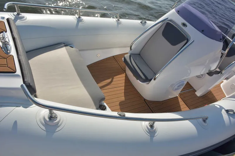 Slide: The Image of 2024 Grand Inflatables G650 boat interior with cushioned seating and teak flooring. - 8