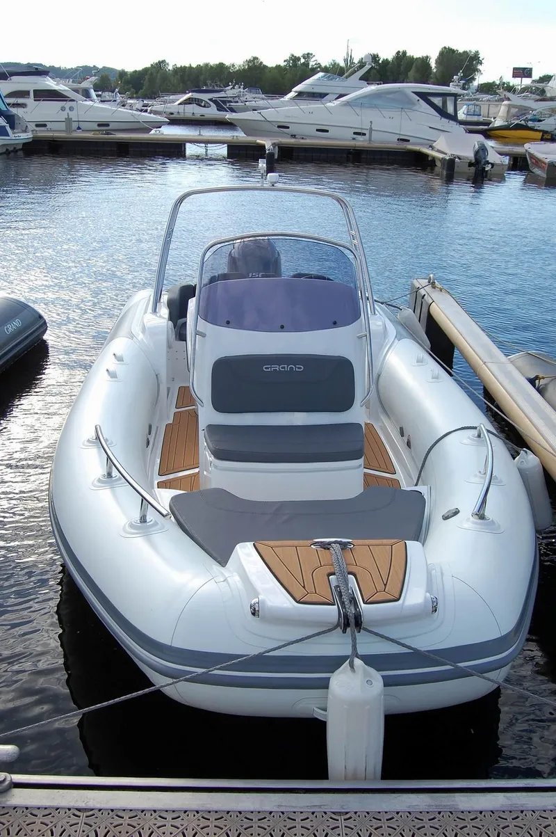 Slide: The Image of 2024 Grand Inflatables G580 boat docked at a marina. - 12