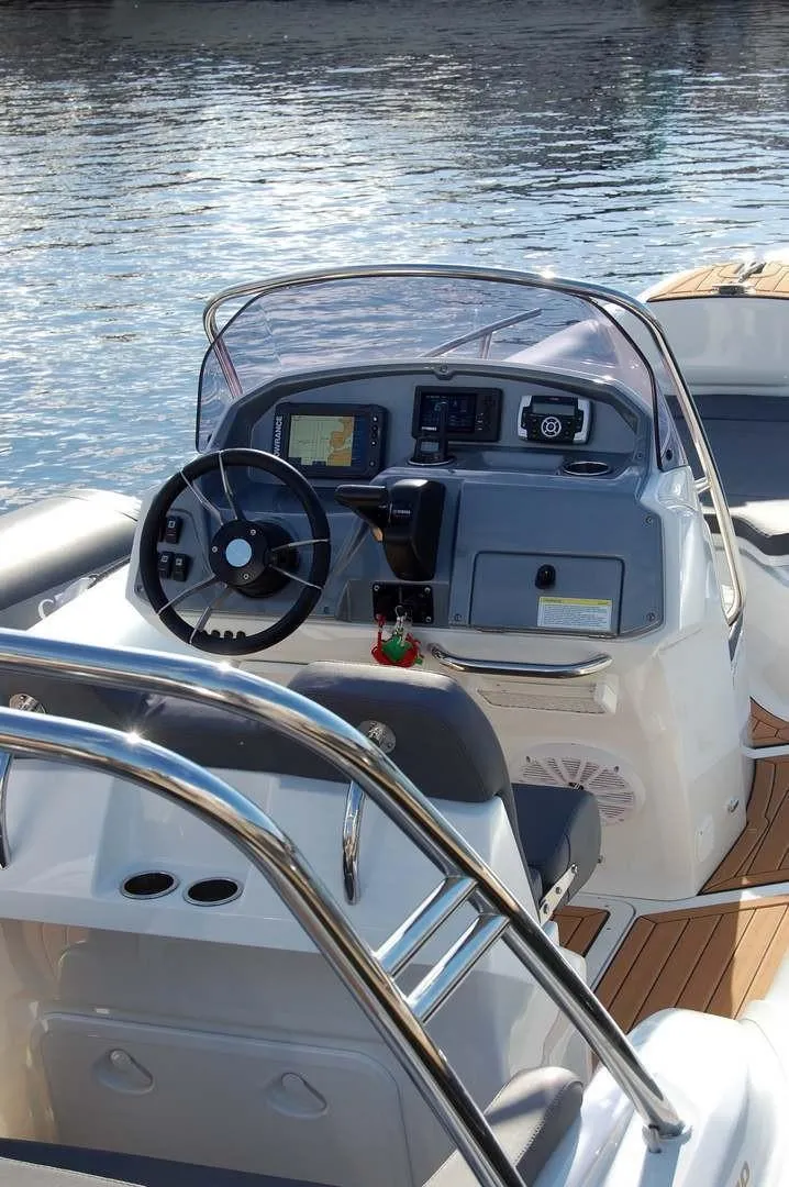 Slide: The Image of 2024 Grand Inflatables G580 boat dashboard with steering wheel and navigation controls. - 15
