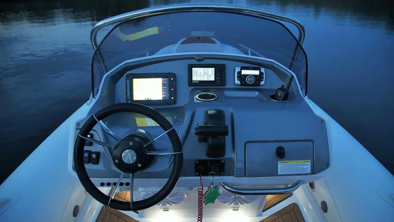 Slide: The Image of 2024 Grand Inflatables G580 boat dashboard with steering wheel and navigation instruments. - 16
