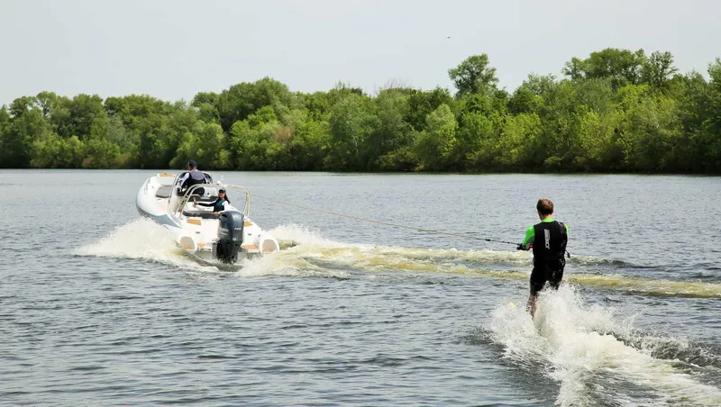 Slide: The Image of 2024 Grand Inflatables G580 towing a water skier on a lake. - 24