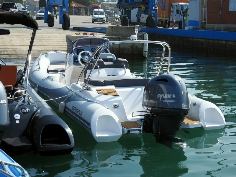 Slide: The Image of 2024 Grand Inflatables G580 boat docked with Yamaha 130 outboard motor. - 25