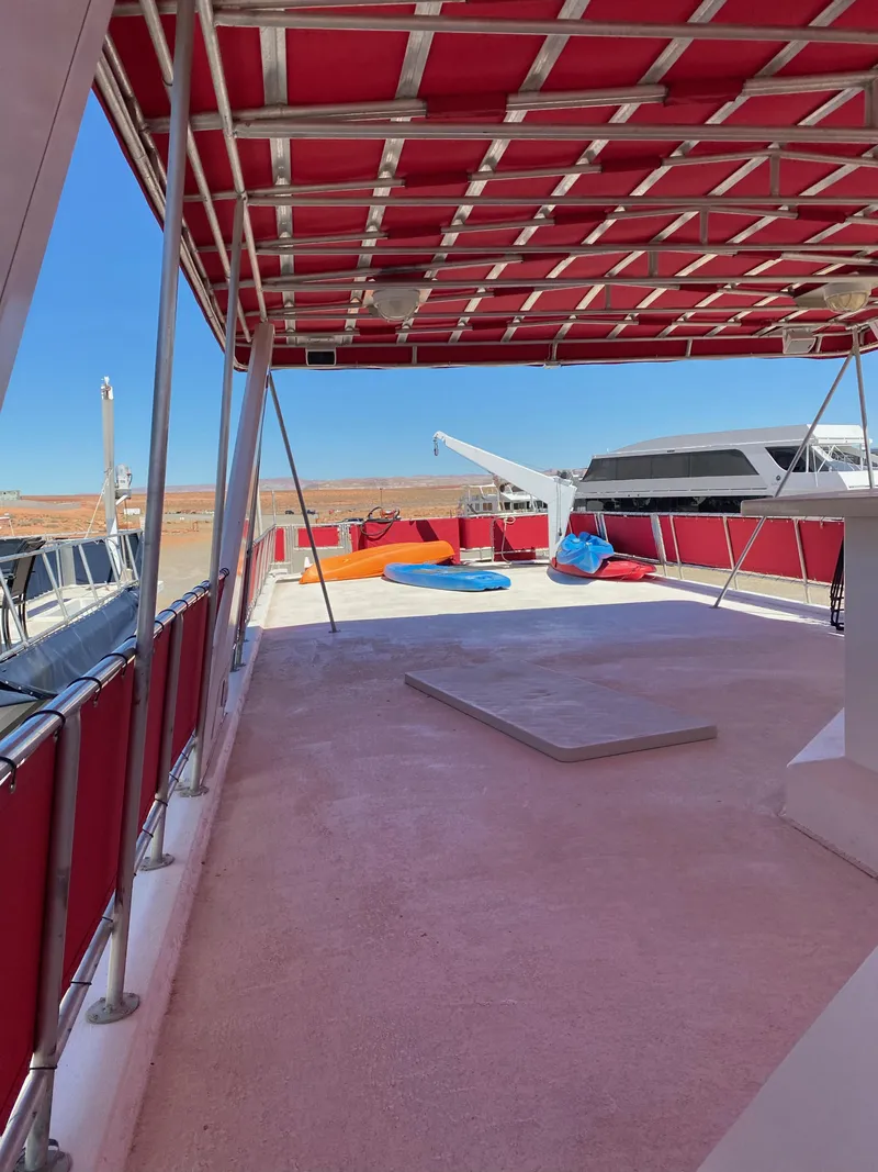 Slide: The Image of 2003 Stardust Cruisers Red Rock Retreat Week 26 houseboat deck with red canopy and lounge chairs. - 30