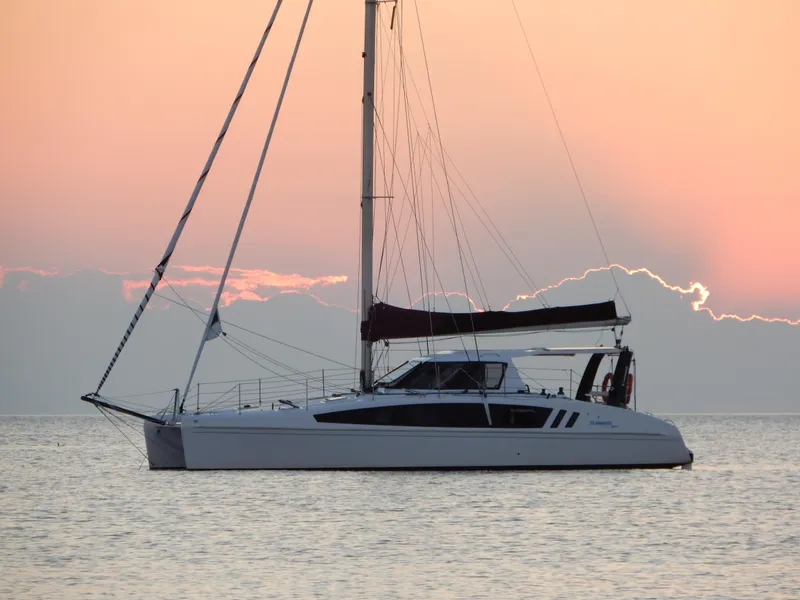 The Image of 2025 Seawind 1190 Sport catamaran sailing at sunset on calm waters. - 0