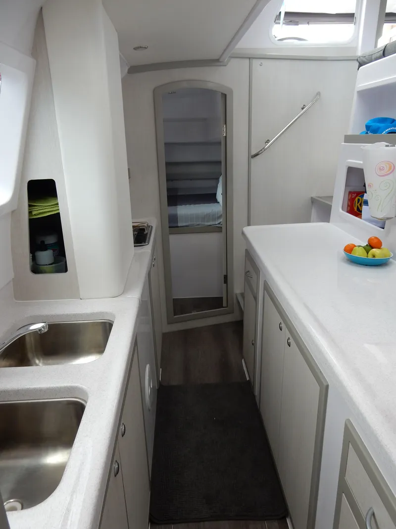 Slide: The Image of Interior of 2025 Seawind 1190 Sport catamaran with modern kitchen and sleek design. - 10