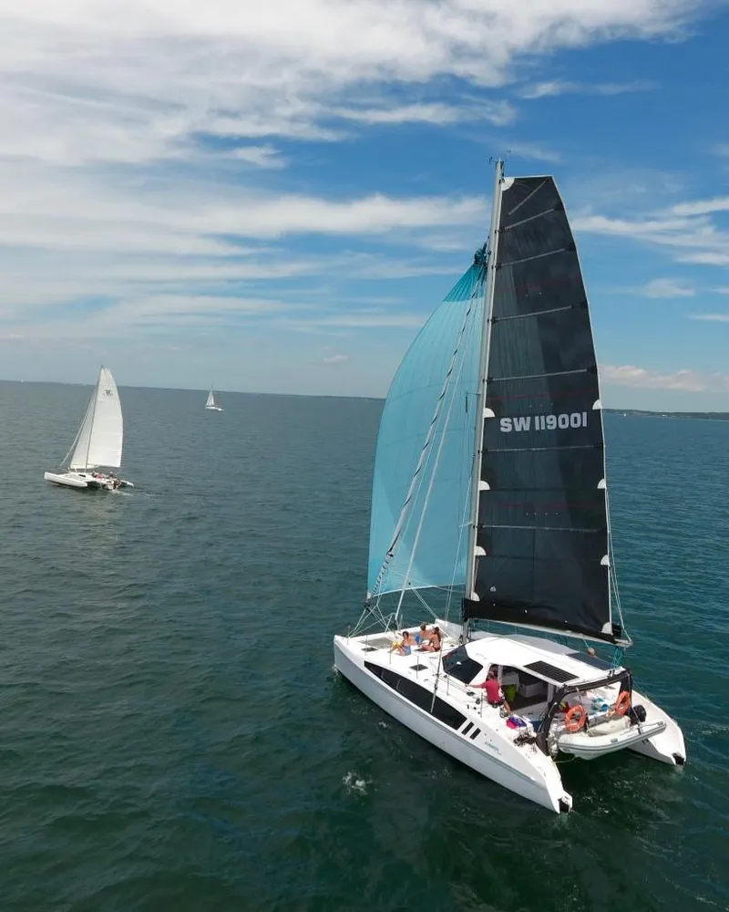 Slide: The Image of 2025 Seawind 1190 Sport catamaran sailing on open water under clear skies. - 3