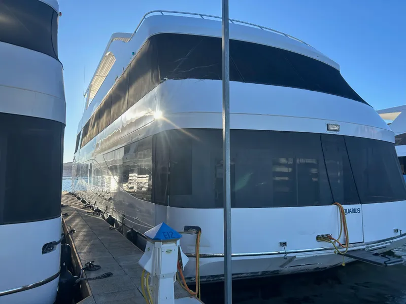 Slide: The Image of Luxury yacht Adonia Aquarius, 2016 model, docked in marina under clear blue sky. - 7