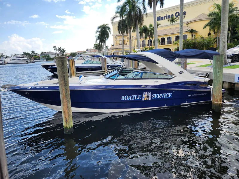 Slide: The Image of 2012 Monterey 328 Super Sport boat docked at a marina with palm trees. - 28