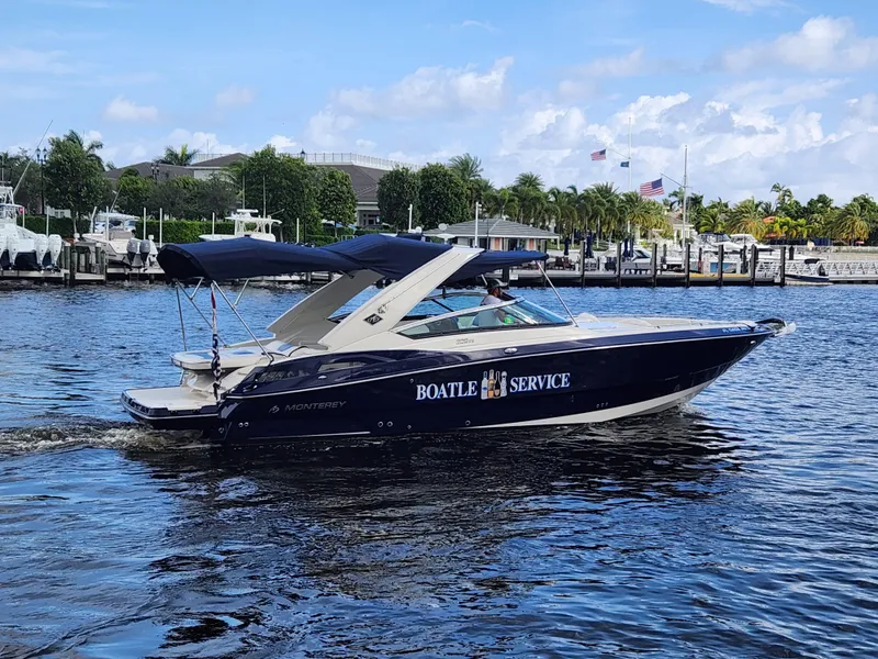 Slide: The Image of 2012 Monterey 328 Super Sport boat on water, Boatel Service signage, marina background. - 40