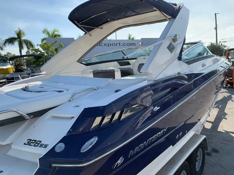 Slide: The Image of 2012 Monterey 328 Super Sport boat in blue and white, docked on a trailer. - 6