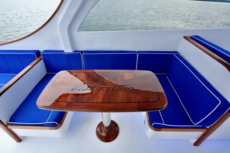 Slide: The Image of 2018 Maverick Yachts Costa Rica 32 Custom Carolina Picnic Boat interior with blue seating and wooden table. - 13