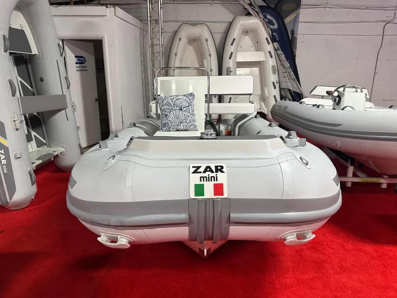 Slide: The Image of 2024 Zar Formenti ZAR Mini RIB 14 inflatable boat on display, red carpet background. - 2