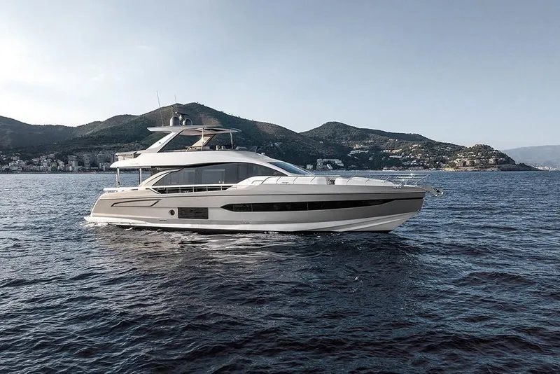 Slide: The Image of 2023 Azimut 78 yacht cruising on open water with scenic mountain backdrop. - 1