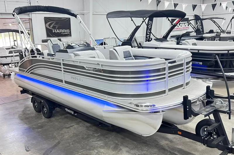 The Image of 2022 Harris FloteBote SOLTHICE 250 pontoon boat displayed indoors on a trailer. - 0