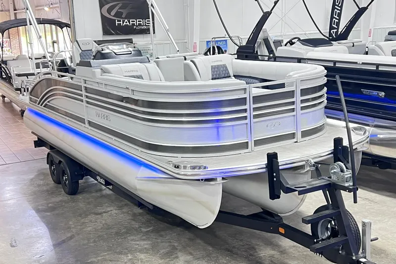 Slide: The Image of 2022 Harris FloteBote SOLTHICE 250 pontoon boat displayed indoors on a trailer. - 4