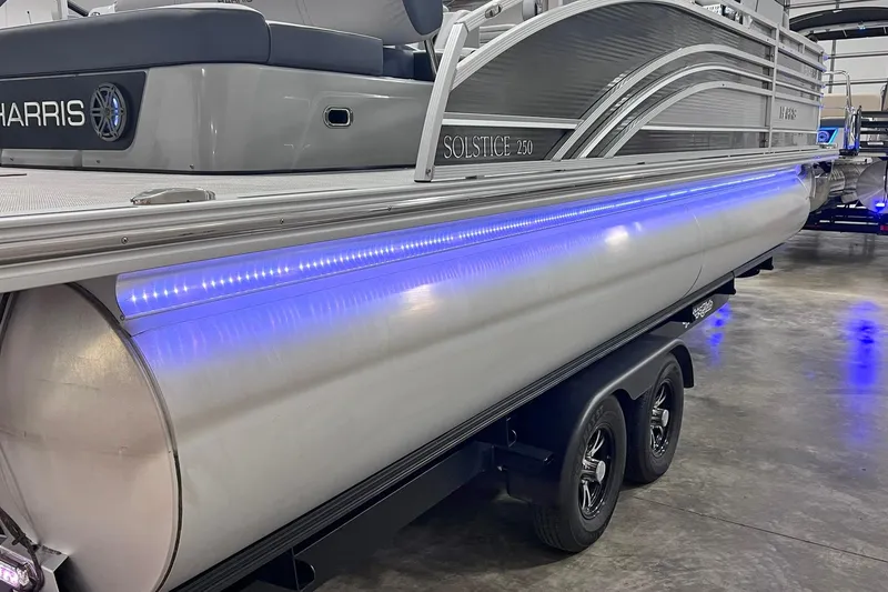 Slide: The Image of 2022 Harris FloteBote SOLTHICE 250 pontoon boat with blue LED lighting on trailer. - 54