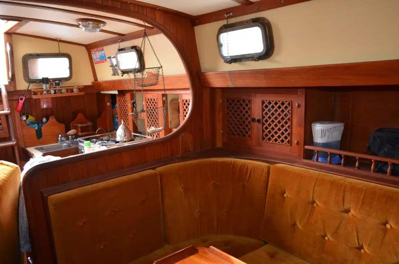 Slide: The Image of Interior of 1982 Young Sun Cutter sailboat with wooden furnishings and cozy seating area. - 12
