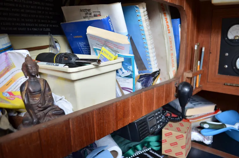 Slide: The Image of Interior of 1982 Young Sun Cutter with books, tools, and a Buddha statue on a wooden shelf. - 18