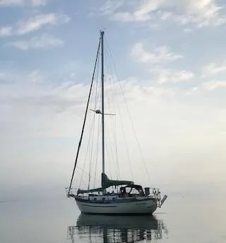 Slide: The Image of 1982 Young Sun Cutter sailboat on calm water under a cloudy sky. - 2