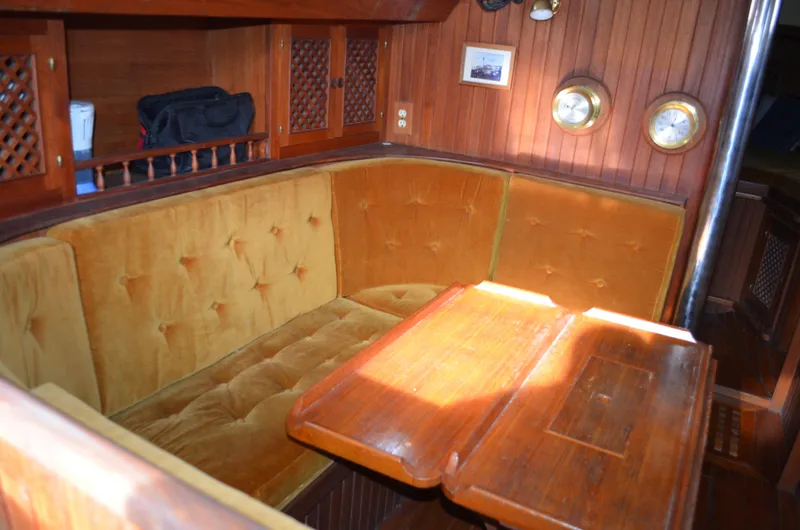 Slide: The Image of 1982 Young Sun Cutter interior with wooden table, cushioned seating, and nautical decor. - 25