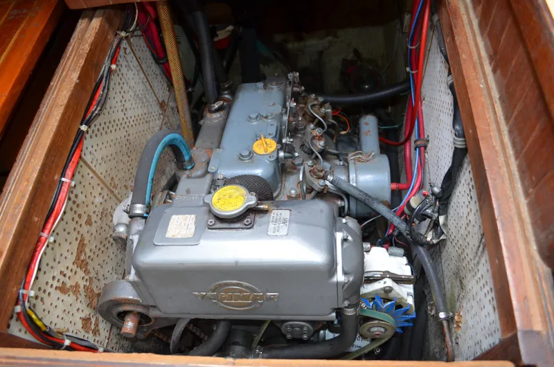 Slide: The Image of Engine compartment of a 1982 Young Sun Cutter sailboat, showcasing mechanical components and wiring. - 26